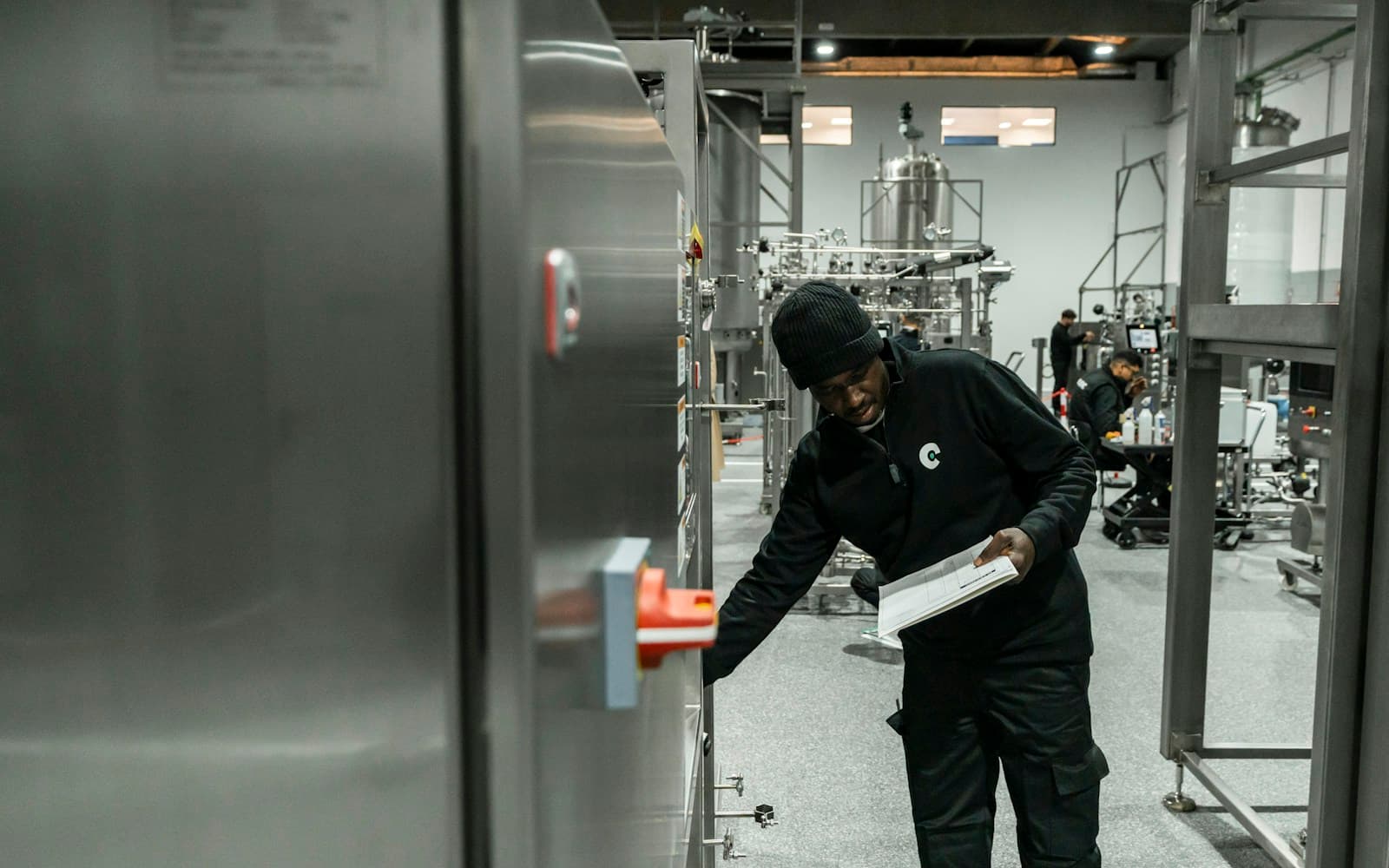 Technician inspecting industrial equipment with a checklist